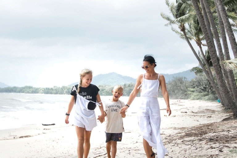 Keluarga berjalan-jalan di pantai di Palm Cove © Tourism and Events Queensland