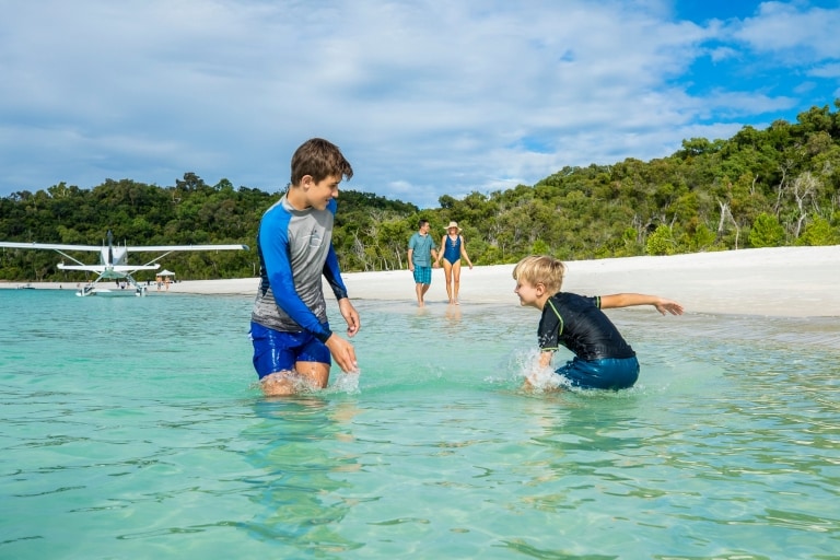 Due bambini sguazzano nell'acqua alla Whitehaven Beach nel Queensland © Tourism and Events Queensland