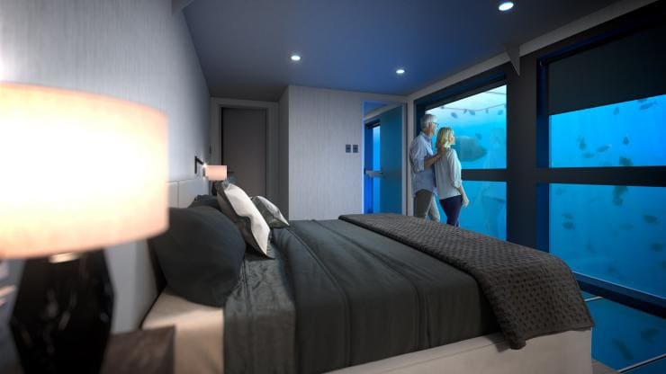 Paar im Schlafzimmer der unter Wasser gelegenen Reef Suite © Cruise Whitsundays