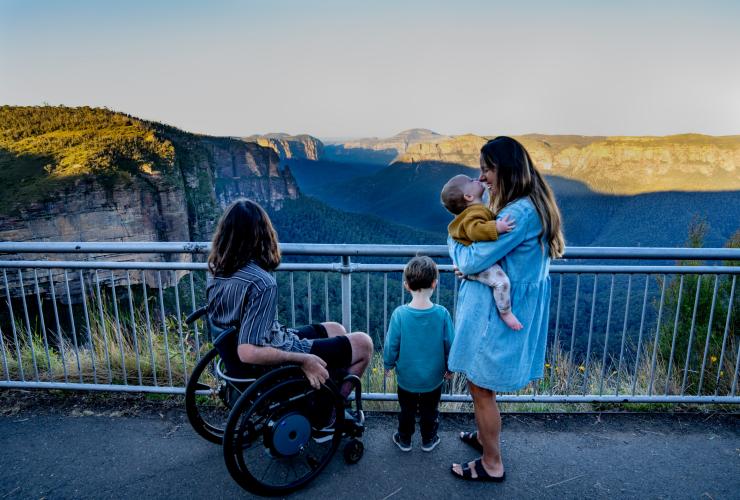 Ein Mann in einem Rollstuhl mit seiner Familie beim Genießen des Ausblicks in den Blue Mountains, New South Wales © Tourism Australia