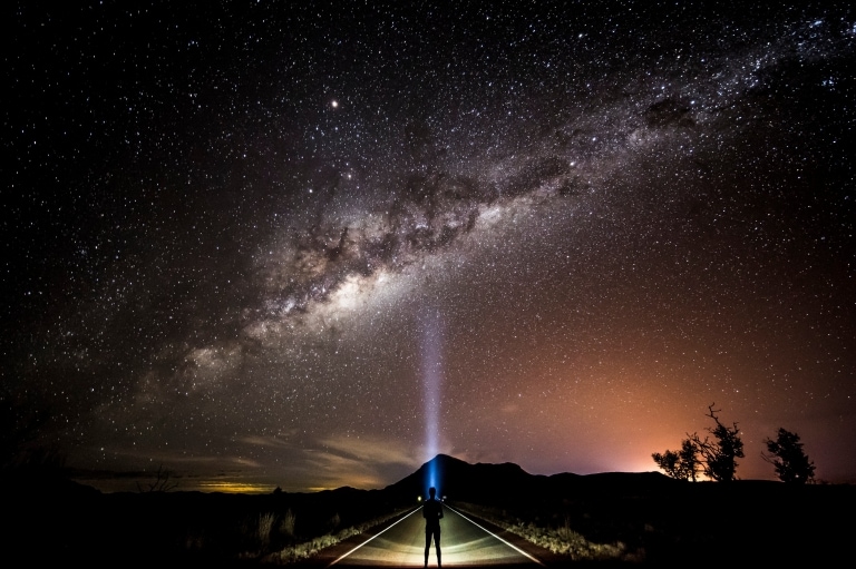 Stargazer with a head torch looking up at the milky way © Tourism and Events Queensland/Sean Scott