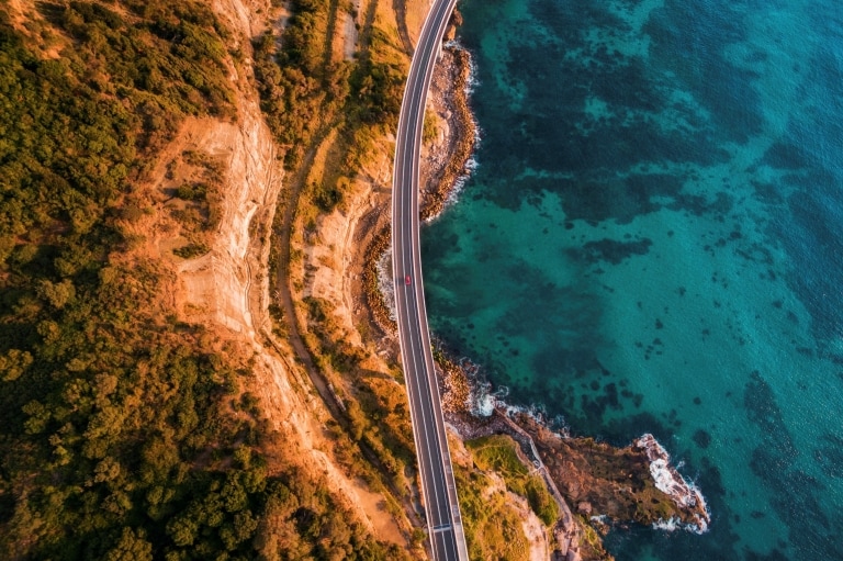 Luftaufnahme der Sea Cliff Bridge über dem Ozean in Clifton, New South Wales © Destination NSW