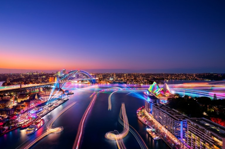 Vue aérienne d'une ville portuaire illuminée par des lumières hautes en couleur pendant le festival Vivid Sydney, Sydney, Nouvelle-Galles du Sud © Destination NSW