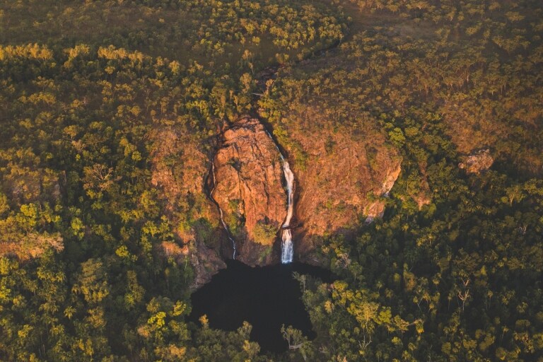 ノーザンテリトリー、夕暮れ時のリッチフィールド国立公園のワンギ・フォールズと周囲の緑地の空撮 © Tourism NT/Jackson Groves