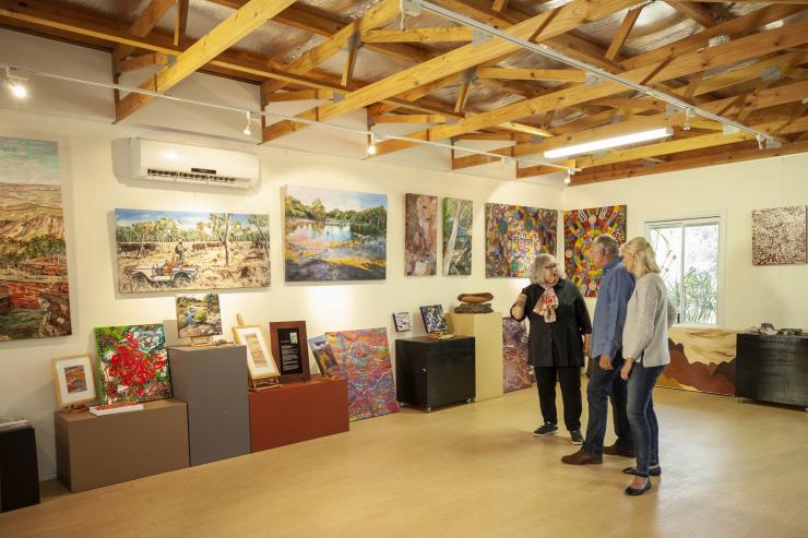 Two guests standing with an Aboriginal guide in an art gallery during a tour with Dale Tilbrook Experiences, Maalinup Gallery, Western Australia © Tourism Australia