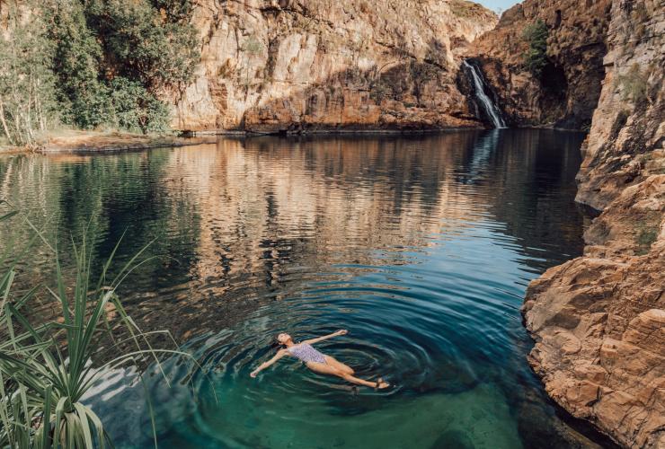 Eine Person lässt sich auf dem Rücken im türkisfarbenen Wasser treiben, umgeben von Felswänden, Barramundi Gorge (Maguk), Kakadu National Park, Northern Territory © Tourism NT/Adriana Alvarado