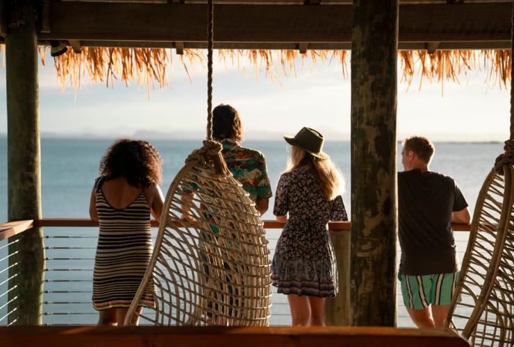 Eine Gruppe von Menschen steht auf einem Balkon und blickt auf den Ozean, Pumpkin Island, Southern Great Barrier Reef, Queensland © Tourism and Events Queensland