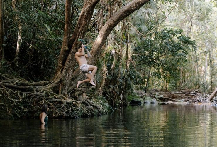 A man uses a rope to jump into the water at Cape Tribulation, Tropical North Queensland, Queensland © Tourism Australia