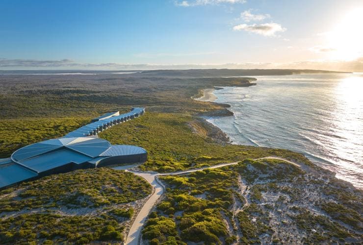 Aerial view over a row of accommodation set among bushland, tracing a rugged coastline at Southern Ocean Lodge, Kangaroo Island, South Australia © Baillie Lodges