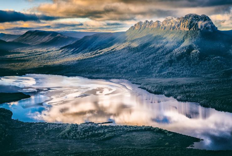 View of Bathurst Harbour reflecting the cloudy sky and surrounded by mountains and greenery at Par Avion Wilderness Tours’ Southwest Wilderness Camp, Bathurst Harbour, Tasmania © Matt Glastonbury