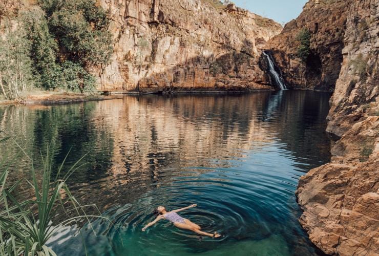 A person floating on their back in the clear, blue-green waters of Barramundi Gorge (Maguk), Kakadu National Park, NT © Tourism Northern Territory/Adriana Alvarado