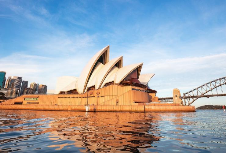 View looking over the water of Sydney Harbour towards the Sydney Opera House during sunrise in Sydney, New South Wales © Destination NSW