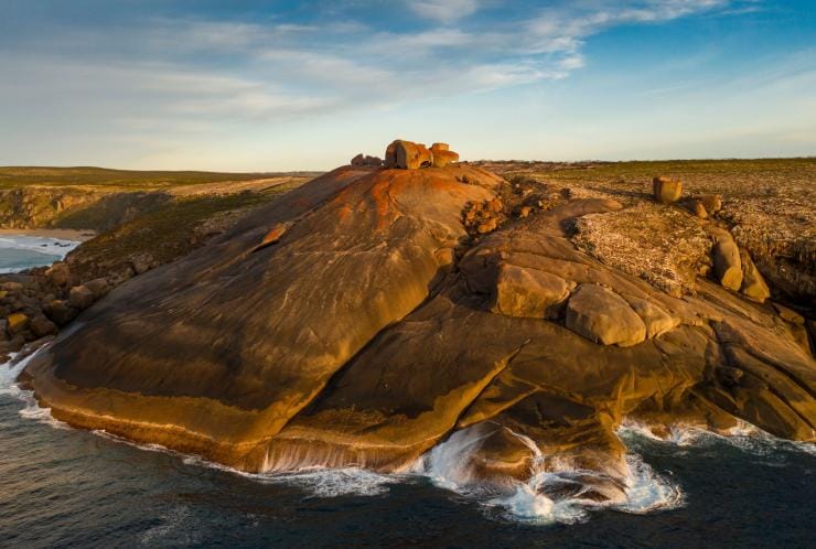 The intriguing formations of the orange lichen-covered Remarkable Rocks resting atop a rocky headland with the ocean below on Kangaroo Island, South Australia © South Australian Tourism Commission