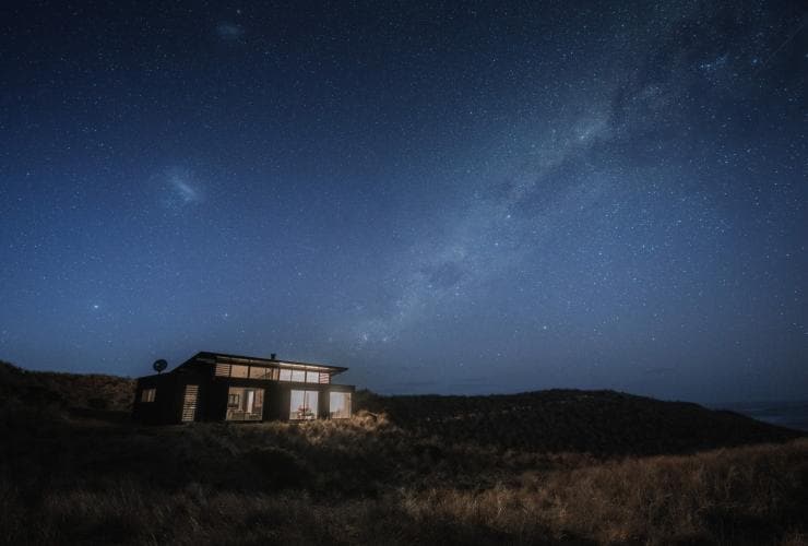 A building perched on a grassy hill at night beneath a blanket of stars at Kittawa Lodge, King Island, Tasmania © Jason Charles Hill