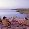 A couple relaxing on camp chairs overlooking the ocean at Faraway Bay, the Kimberley, Western Australia © Wild Bush Luxury