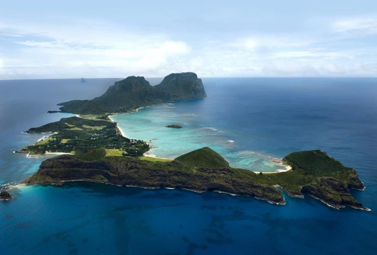 Aerial view over the green mountain peaks and vibrant blue water of Lord Howe Island, New South Wales © Baillie Lodges