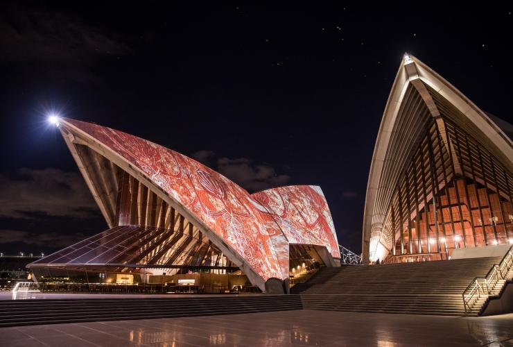 Ciel nocturne avec voiles de l'Opéra de Sydney illuminées aux couleurs des œuvres d'art rouges des peuples aborigènes d'Australie, Sydney, Nouvelle-Galles du Sud © Daniel Boud