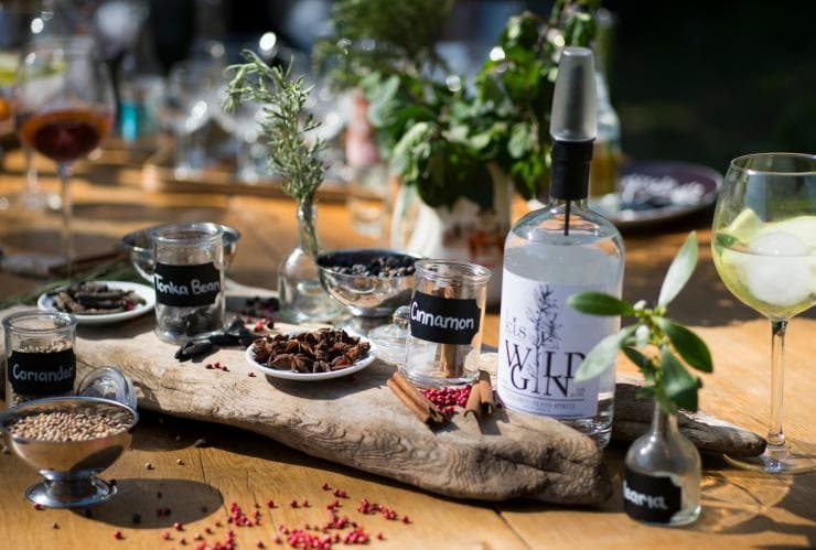 Une table sur laquelle se trouvent une bouteille de « wild gin » et des ingrédients tels que de la cannelle et de la coriandre à Kangaroo Island Spirits Distillery, Kangaroo Island, Australie du Sud © Adam Bruzzone