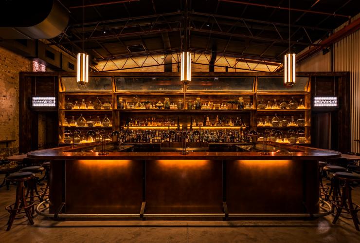 Vista di un bar ben rifornito illuminato da luci soffuse da Archie Rose, Sydney, New South Wales © Archie Rose