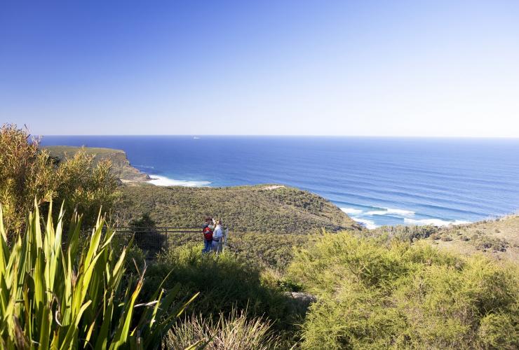 ニュー・サウス・ウェールズ州、シドニー、王立国立公園のガバナー・ゲーム展望台に立って海へと続く緑を見晴らす2人 © Destination NSW