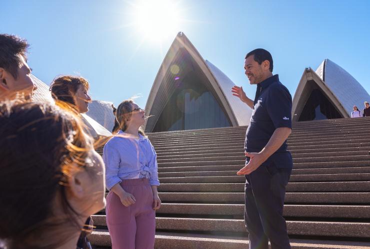 관광객이 지켜보는 가운데 시드니 오페라 하우스의 흰색 돛을 향해 손짓을 하고 있는 가이드의 모습, 시드니, 뉴사우스웨일스 © 호주정부관광청