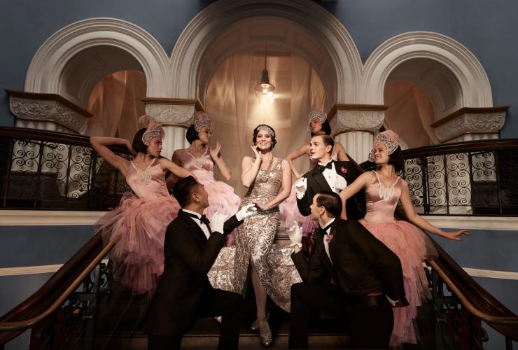 시드니 오페라 하우스에서 진행된 OA 프리젠츠 오페라 더 메리 위도우 공연 중 한 무리의 사람들이 1920년대 의상을 입고 있고 한 여성이 중앙에 서서 다른 사람들이 감탄하는 가운데 미소짓고 있는 모습, 뉴사우스웨일스 © 조르주 안토니(Georges Antoni)
