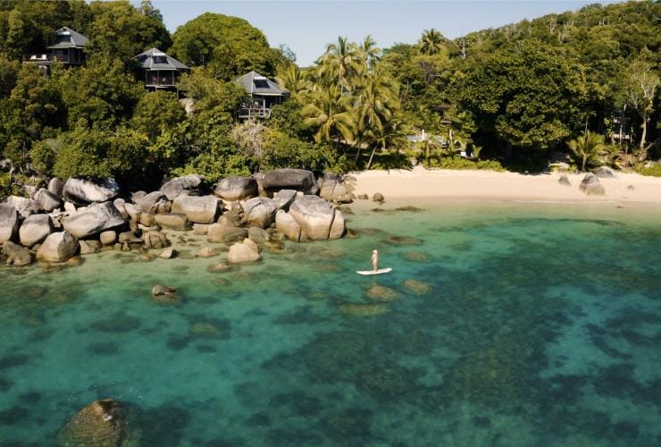 그레이트 배리어 리프의 맑고 푸른 바다, 여기저기 놓여 있는 거대한 바윗돌들, 순백의 모래, 녹색 야자수 나무들이 있는 베다라 아일랜드의 해안선을 공중에서 내려다본 모습, 퀸즐랜드 © 호주정부관광청