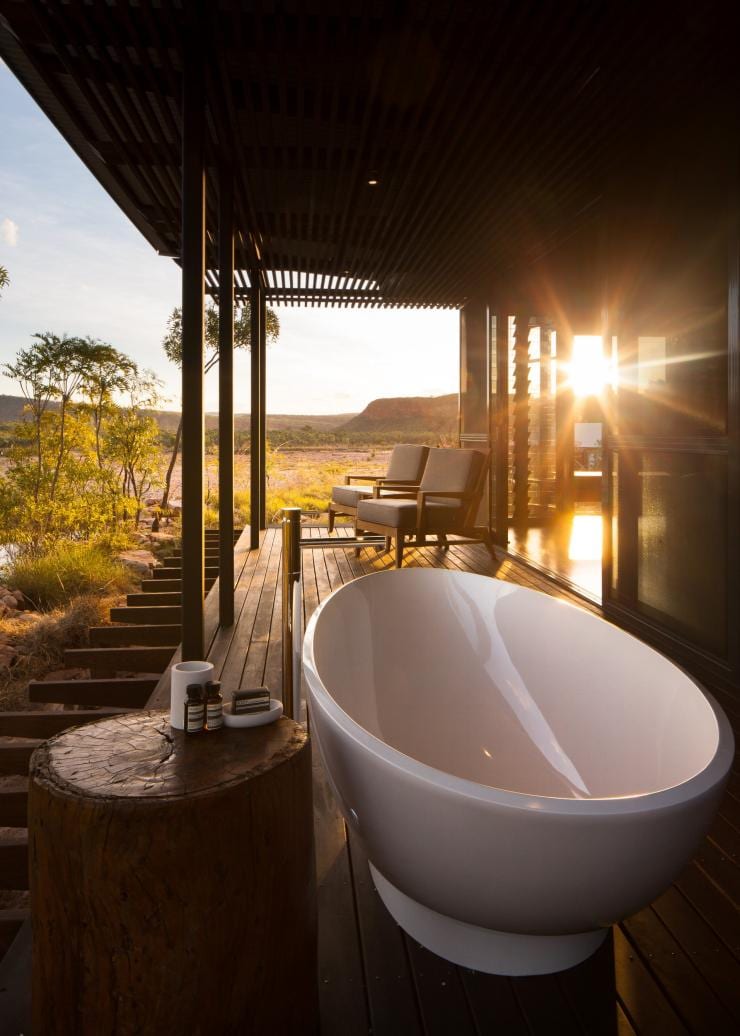 西澳州埃爾奎斯特荒野公園El Questro Homestead的日落景致，門廊上放了戶外浴缸和躺椅，四周圍是大自然景色©Timothy Burgess