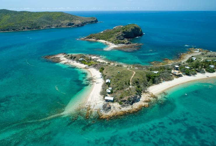 空中俯瞰昆士蘭州南大堡礁南瓜島白色的海岸、藍色的水面和茂密的綠林©昆士蘭旅遊及活動推廣局